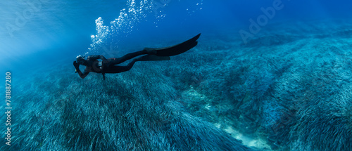 Freediver Swimming in Shallow Sea With Sea Grass.
