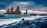 Gloomy morning view of Reynisdrangar cliffs. Picturesque summer seascape of Atlantic ocean. Spectacular outdoor scene of black sand beach in Iceland, Vik location. Travel the world..