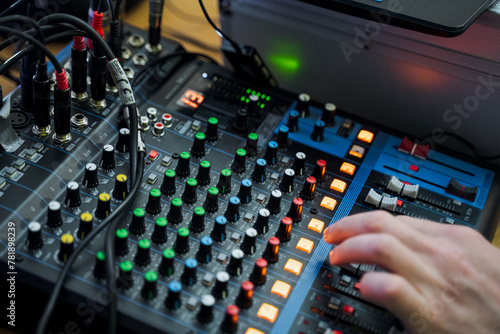 Hand pressing button on mixer, audio equipment in use