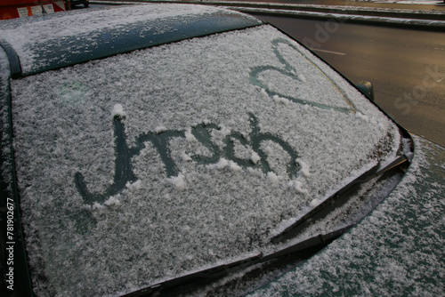 auf der frontscheibe eines autos in schnee geschriebene nachricht.