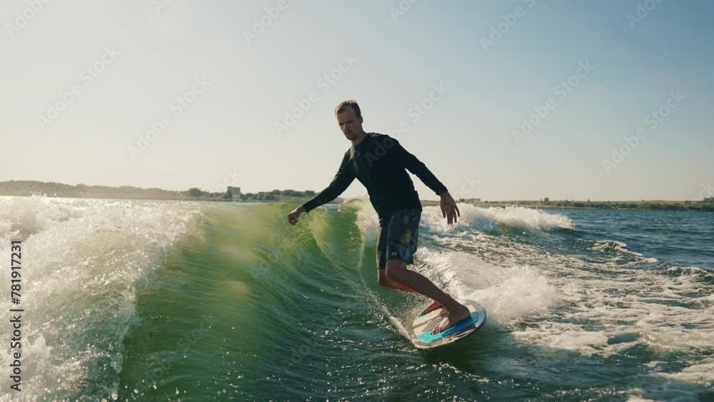 Wakeboarding. A wakeboarder glides on the water behind a boat. Skilled wakeboarding Wakeboarding. A wakeboarder glides on the water behind a boat. Skilled wakeboarding