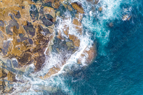waves breaking on the rocks of the coast, aerial top view with a drone.