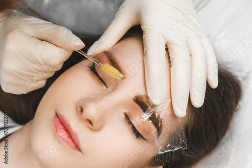 A cosmetologist applies permanent makeup to the eyebrows - eyebrow tattoo. eyebrow perm