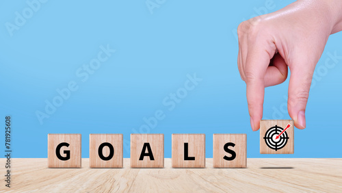 Hands place virtual target board and arrows on wooden block, Business success goals and objective goal concept, Achieving goals and objectives or goal setting concept.