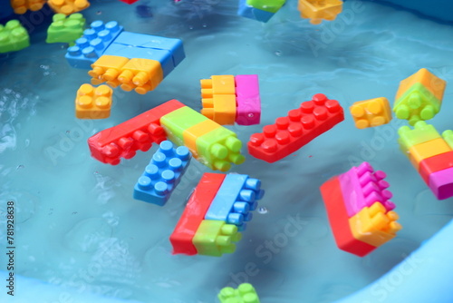 Bild auf Leinwand building blocks are floating in the water and giving resemblance of tsunami