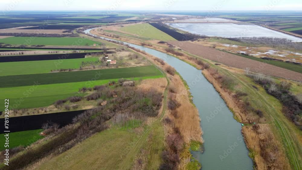 Green agricultural fields and large fish pond surround river Bega in countryside Green agricultural fields and large fish pond surround river Bega in countryside