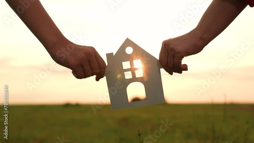 hands holding paper house, window sunset ray, happy family mortgage build new house, home buying guide, housing market trends, mortgage rates today, moving house checklist, new construction homes photo