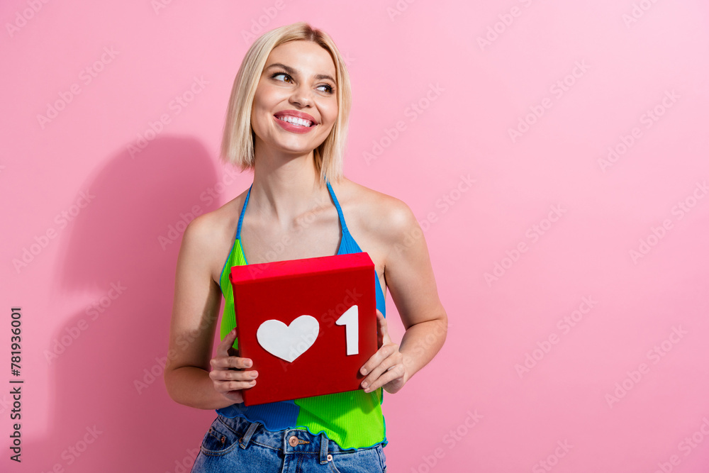 Photo of nice girl with bob hairdo dressed colorful tank hold heart reaction look at logo empty space isolated on pink color background Photo of nice girl with bob hairdo dressed colorful tank hold heart reaction look at logo empty space isolated on pink color background