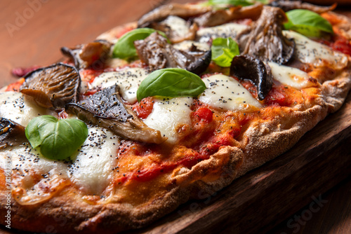 Primo piano di una deliziosa pinsa romana condita con mozzarella, sugo e funghi, cibo italiano 