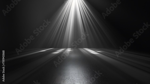 A spotlight shines down on a dark stage. The spotlight is surrounded by a soft  hazy light. The stage is empty  except for a few shadows.