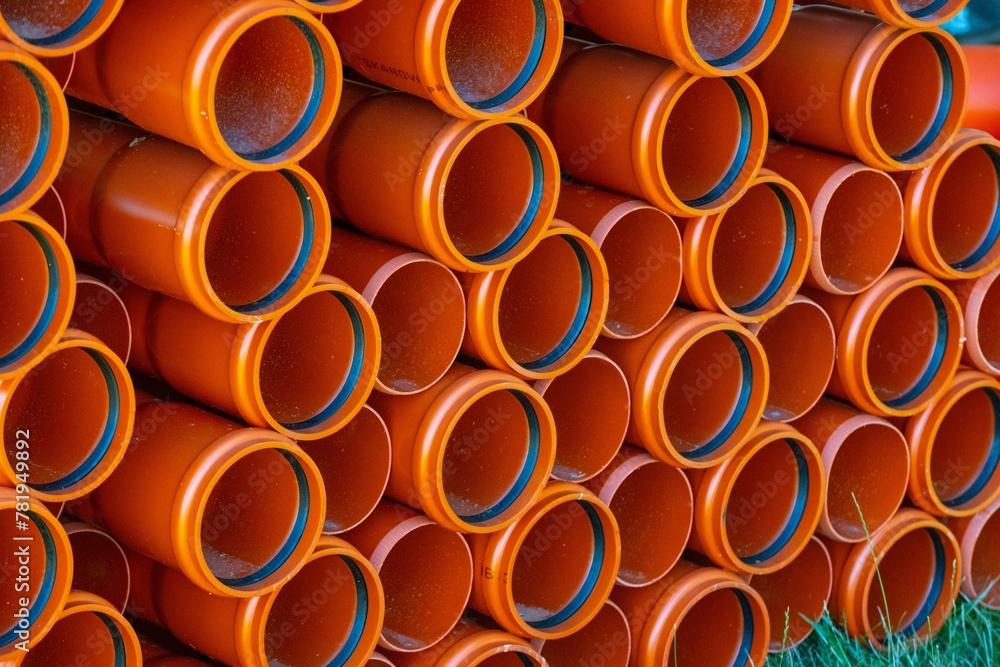 Closeup of pvc pipes on a stack on green grass Closeup of pvc pipes on a stack on green grass