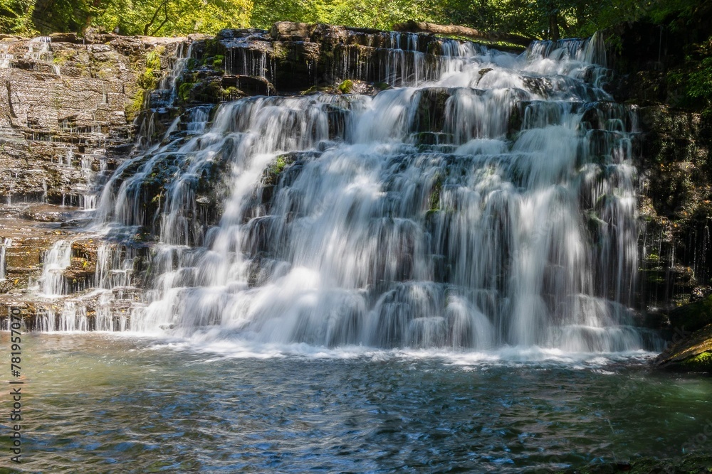 Beautiful shot of a waterfall during the day in a forest Beautiful shot of a waterfall during the day in a forest