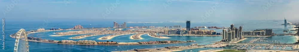 panoramic aerial city view of Dubai with the artificial island Palm Jumeirah and many other famous buildings along the coastline of Dubai
