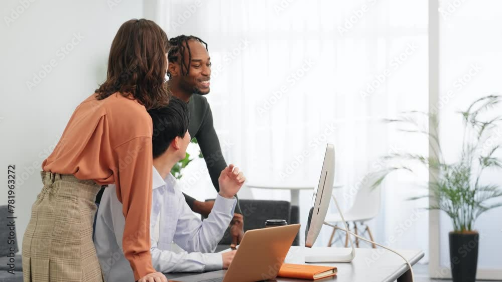 Multinational people talking while looking at desktop PC in the lobby. International business.