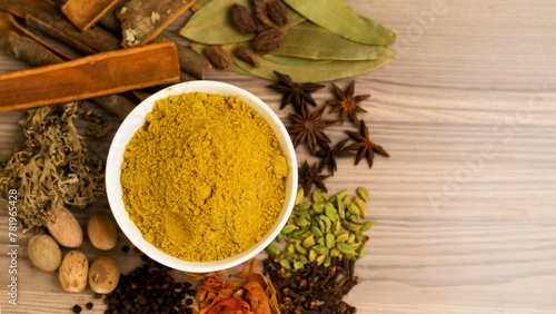 Indian spices on a table with Indian bay leaf, javitri, dry turmeric dust, nutmeg, garam masala photo