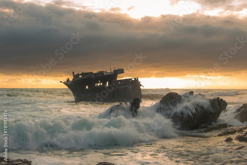 Fototapeta Naklejka Na Ścianę i Meble -  Image of a sing ship in the waves of the sea during the yellow sunset.
