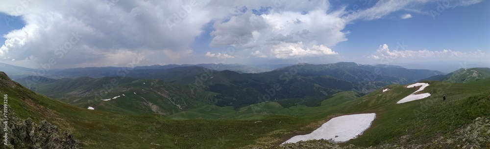 Panoramic view of the rocky mountain range with the green field in Teghenis, Armenia