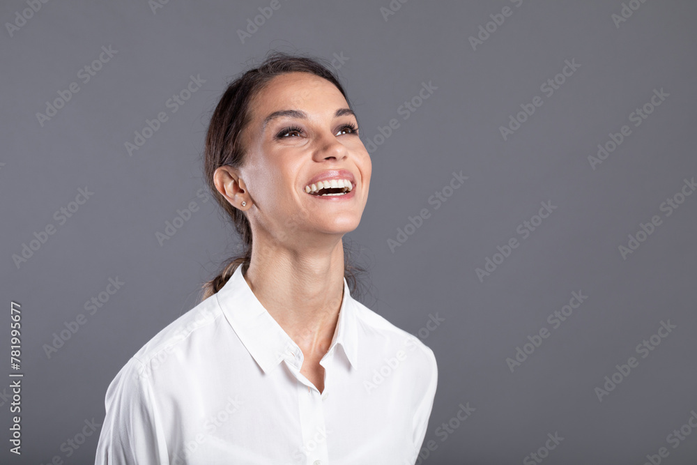 Businesswoman studio portrait looking to the side. Confidence woman in elegant white shirt isolated Businesswoman studio portrait looking to the side. Confidence woman in elegant white shirt isolated