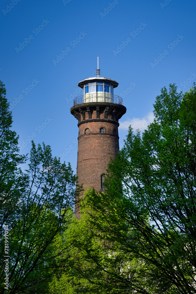 the historic helios lighthouse behind trees and against a blue sky