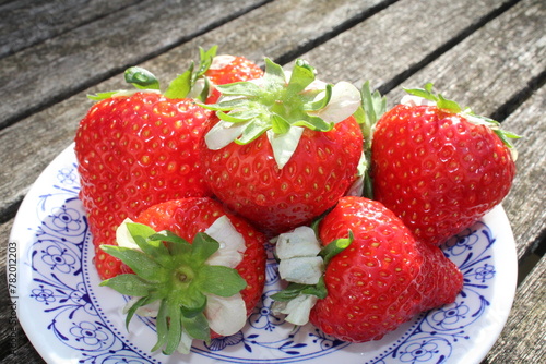 Fresh strawberries on a blue plate