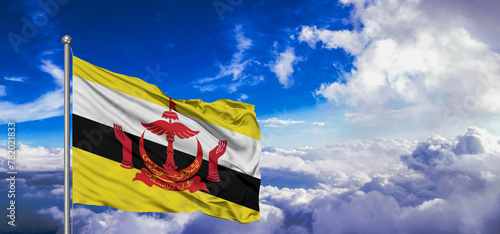 Brunei national flag cloth fabric waving on beautiful Blue Sky Background.