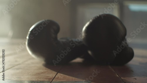 boxing gloves on the wooden floor in the gym, then they are lifted photo