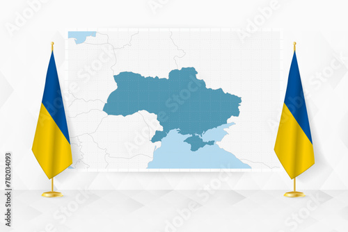 Map of Ukraine and flags of Ukraine on flag stand.