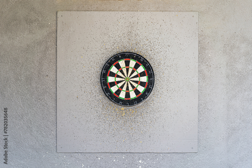 Use classic professional sisal dart board on gray wooden background. Close up