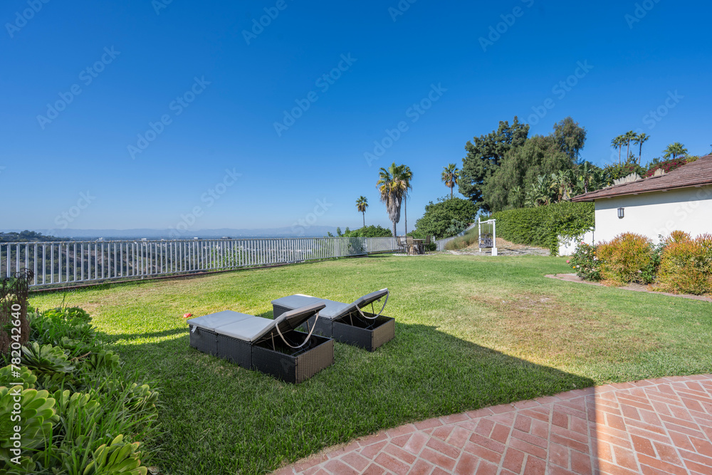 Lawn chairs in a backyard with palm tree views in Hidden Hills, CA