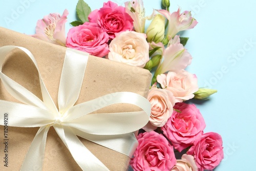 Happy Mother s Day. Beautiful flowers and gift box on light blue background  flat lay