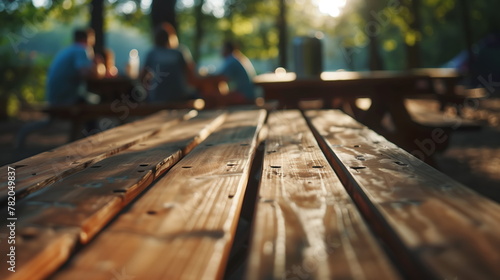 Empty wooden table in the camping with blurred people at background