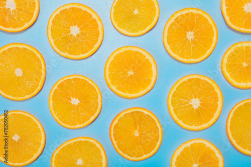 Slices of juicy orange on light blue background  flat lay