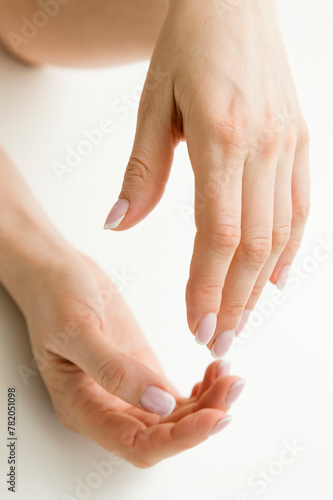 The woman's hands seem to be holding something. Ready to help or accept. Gesture isolated on white background. A helping hand is stretched out to save. Decorated with a French manicure. photo