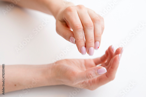 The woman's hands seem to be holding something. Ready to help or accept. Gesture isolated on white background. A helping hand is stretched out to save. Decorated with a French manicure.