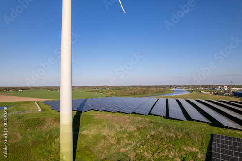 Closeup of wind turbine and solar panel in The Netherlands part of sustainable industry Dutch along river IJssel and Twentekanaal waterway picturesque landscape. Aerial circular economy future concept
