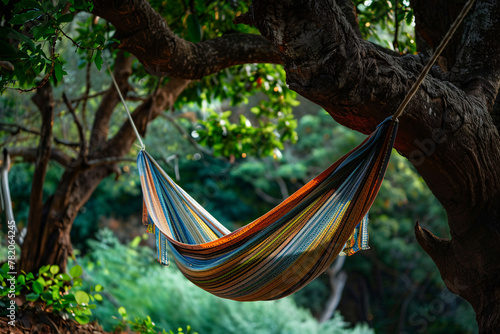 Colorful hammock hanging on green tree photo