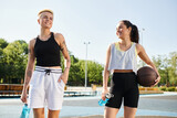 Two young women, friends and basketball players, stand confidently side by side outdoors.