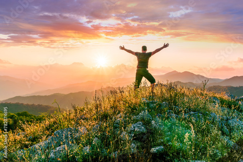 happy man watching amazing highland evening sunset, person delight with nature landscape