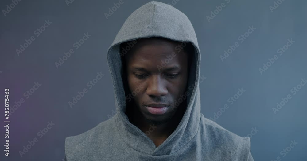 Close-up slow motion portrait of confident African American man in sportswear raising head looking at camera on purple background. Sports and active lifestyle concept. Close-up slow motion portrait of confident African American man in sportswear raising head looking at camera on purple background. Sports and active lifestyle concept.