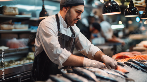 Focused fishmonger in an apron is carefully arranging a selection of fresh fish at a market stall.