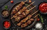 A plate of mouthwatering kebab, featuring juicy lamb meat on wooden sticks, served with salt and pepper for embellishment. The dish is placed against the backdrop of a dark gray tabletop