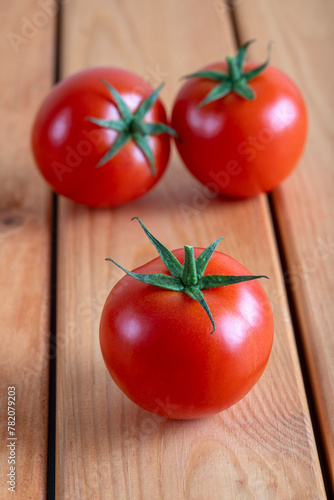 A group of tomatoes on a wooden floor, top view