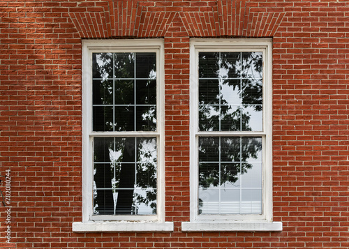 Reflection of light on vertically oriented white-framed rectangular windows on a red brick wall, Boston, USA