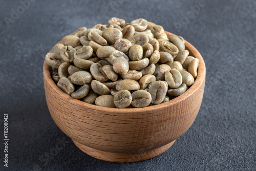 A bowl full of green coffee beans,on black background