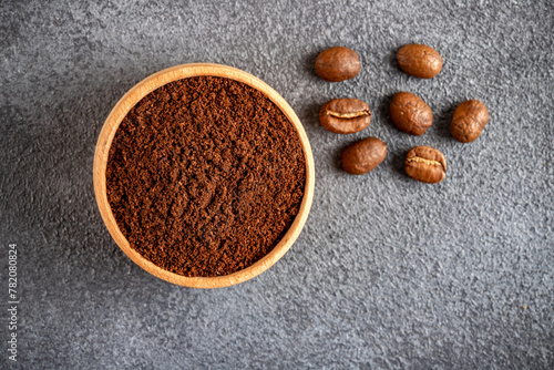 Ground coffee with roasted coffee beans on dark background,top view
