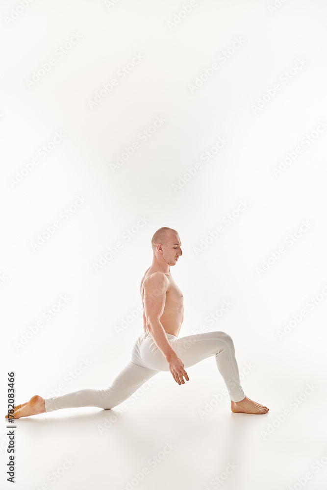 A young man gracefully executes an acrobatic element, showcasing balance and serenity in a studio setting against a white background. A young man gracefully executes an acrobatic element, showcasing balance and serenity in a studio setting against a white background.