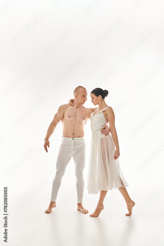 A shirtless young man and a woman in a white dress perform an enchanting dance together, incorporating acrobatic elements.