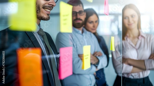 A vibrant scene unfolds as business mavens gather around glass partitions, exchanging ideas fluently through adhesive notes, epitomizing collaborative synergy in action.
 photo