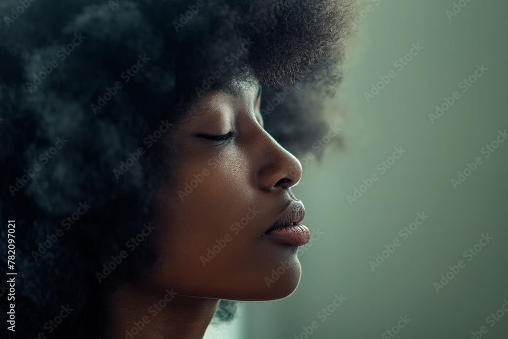 Close-up. Profile of a black woman in an afro on a gray background. Close-up. Profile of a black woman in an afro on a gray background.