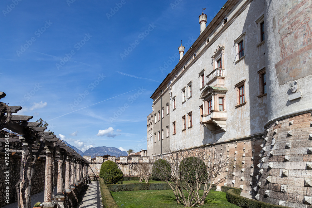 View of garden at Buonconsiglio Castle (Castello del Buonconsiglio) in a beautiful sunny day in Trento, Trentino-Alto Adige, Italy; Dolomites mountains in the background